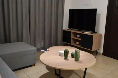 a living room with a coffee table and a tv at Pebble in Protaras