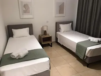 a room with two beds and a night stand at Pebble in Protaras