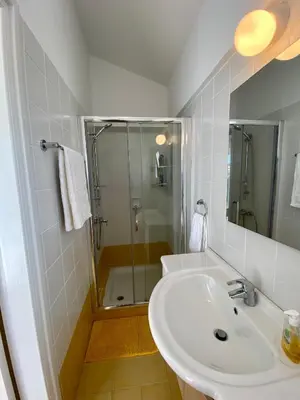 a white bathroom with a shower and a sink at Villa Lorena Protaras in Protaras