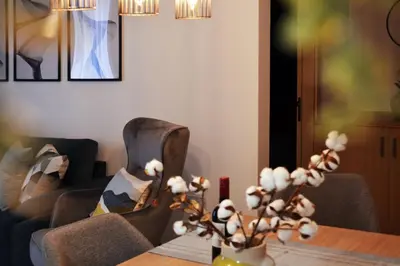 a living room with two chairs and a table with flowers at Sweet Retreat in Paralimni