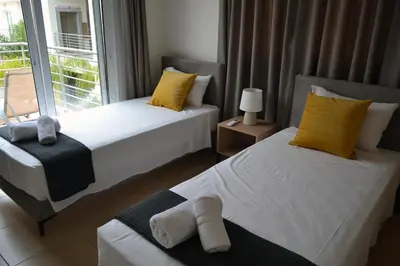 a bedroom with two beds with yellow pillows and a window at Sweet Retreat in Paralimni