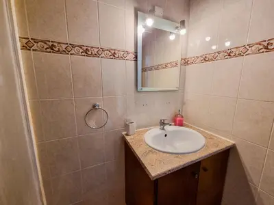 a bathroom with a sink and a mirror at Seaside Heaven Apartment With Pool in Larnaka