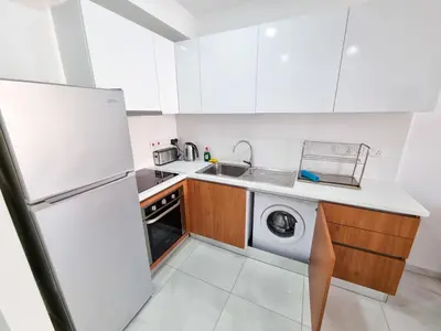 a kitchen with a washer and dryer in it at Sea Bay Apartment in Larnaka
