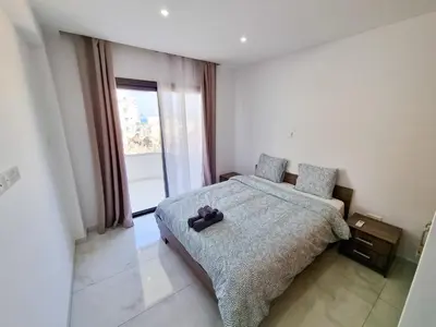 a bedroom with a bed with a teddy bear on it at Sea Bay Apartment in Larnaka