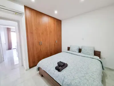 a bedroom with a bed with a teddy bear on it at Sea Bay Apartment in Larnaka