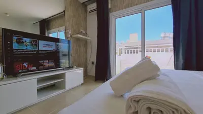 a bedroom with a large screen tv and a bed at STAY Lavish Studio in Ayia Napa