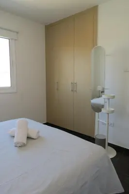 a white bedroom with a bed and a sink at Mythical Sands AM10 in Paralimni