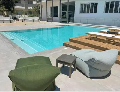 a pool with a couch and a chair and a table at Mythical Sands AM10 in Paralimni