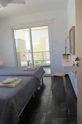 a room with two beds and a sink and a window at Mythical Sands AM10 in Paralimni