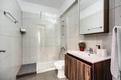 a bathroom with a sink and a toilet and a shower at SunnyVillas: 2BR Mythical Apt*Swimming Pool*AK04 in Paralimni