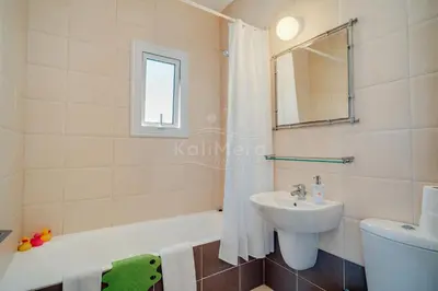 a bathroom with a sink and a tub and a toilet at Villa Sunrise Pernera in Paralimni