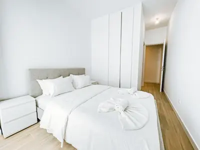 a white bedroom with a large bed with white sheets at Azure Seaview - Jade Villa in Protaras
