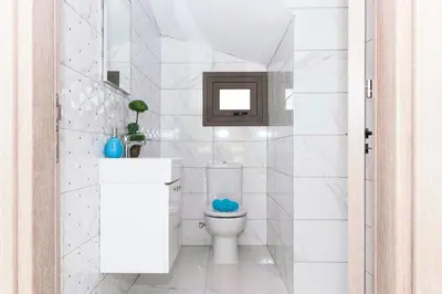 a white bathroom with a toilet and a mirror at Villa Dina in Protaras