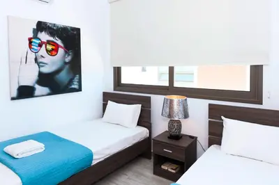 a bedroom with two beds and a picture of a woman wearing sunglasses at Villa Dina in Protaras