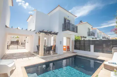 a villa with a swimming pool in front of a house at Sunny Side Up Villa in Protaras