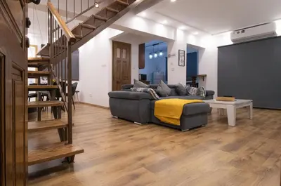 a living room with a couch and a staircase at Maestro Sea - View Apartment in Larnaka