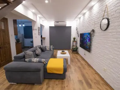 a living room with a couch and a brick wall at Maestro Sea - View Apartment in Larnaka