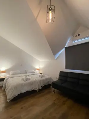 a bedroom with a bed and a black couch at Maestro Sea - View Apartment in Larnaka