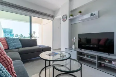 a living room with a couch and a tv at Andrea 3-Bedroom Apt in Mackenzie in Larnaka