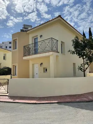 a large yellow house with a white fence at Villa Flory in Protaras